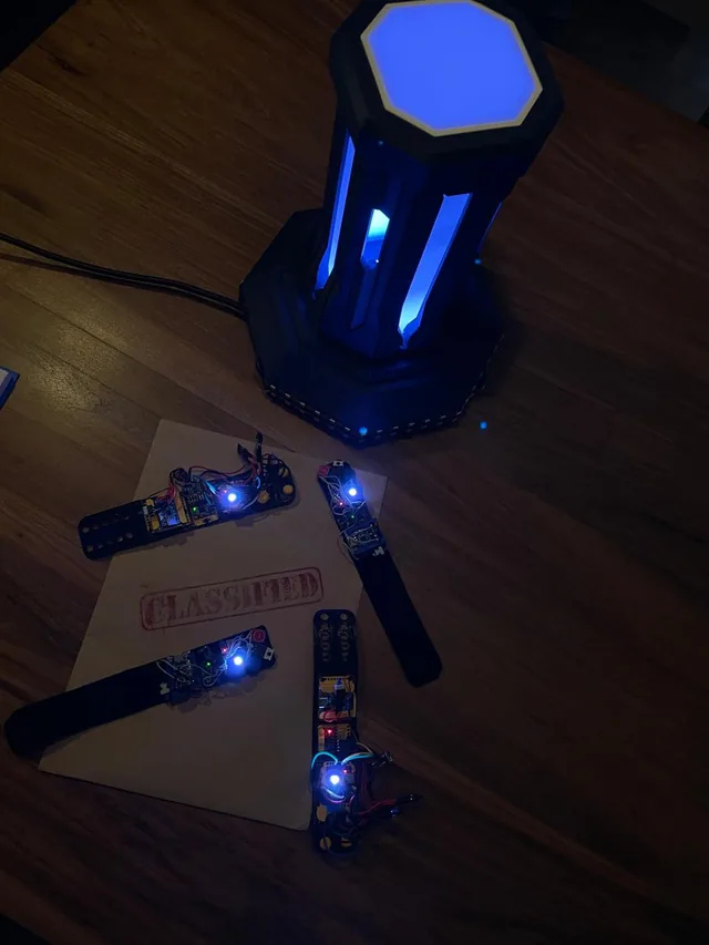 El tótem de Vinculum Play encendido en azul, con las pulseras sobre la mesa